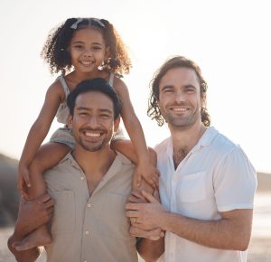 Gay couple, portrait and smile with family at beach for seaside holiday, support and travel. Summer.